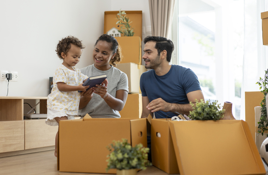 Mom and dad helping young child unload moving boxes
